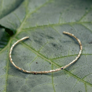 Open solid branch bracelet with gems