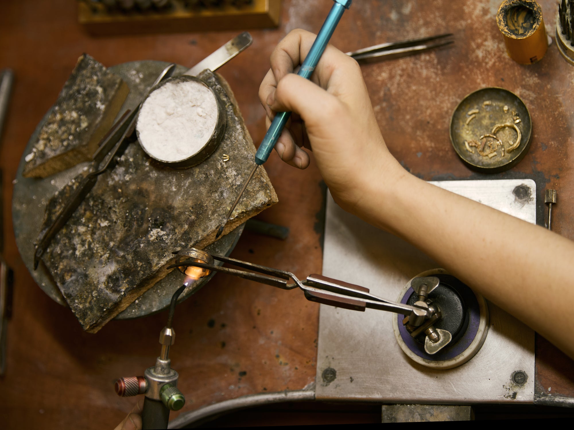 Artisan hands hammering texture into a gold ring
