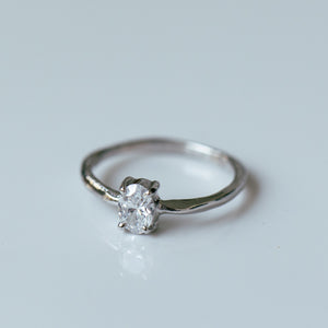 Raw white gold ring with oval white diamond