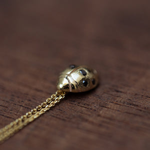 Gold beetle pendant with black diamonds