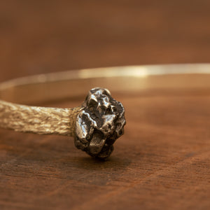 Rough textured silver bracelet with meteorite