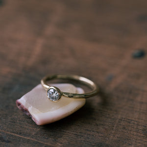 Raw gold ring with bezel champagne setting