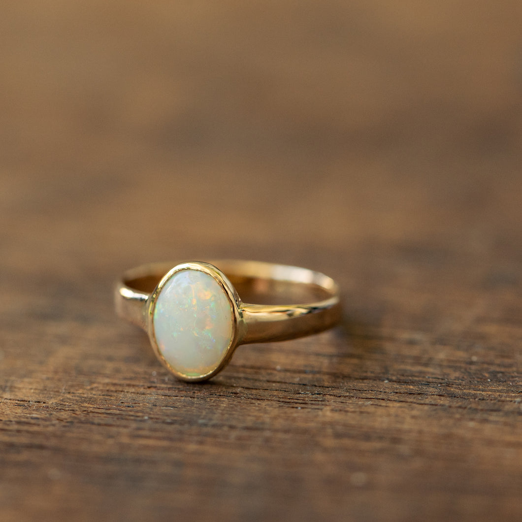 Oval white opal solitaire ring